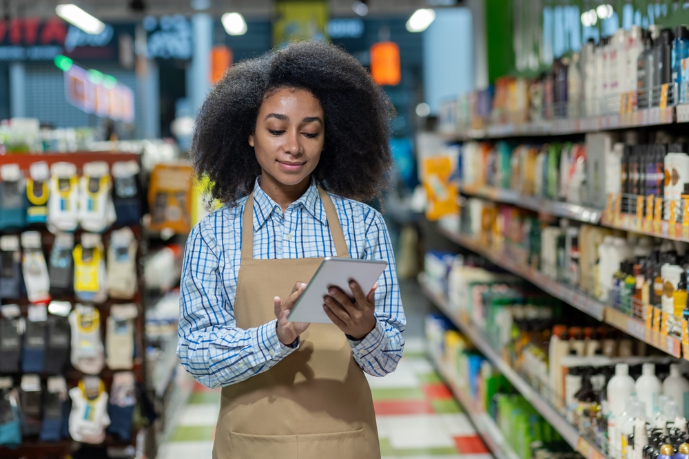 Female,Employee,In,A,Retail,Store,Aisle,,Using,A,Tablet